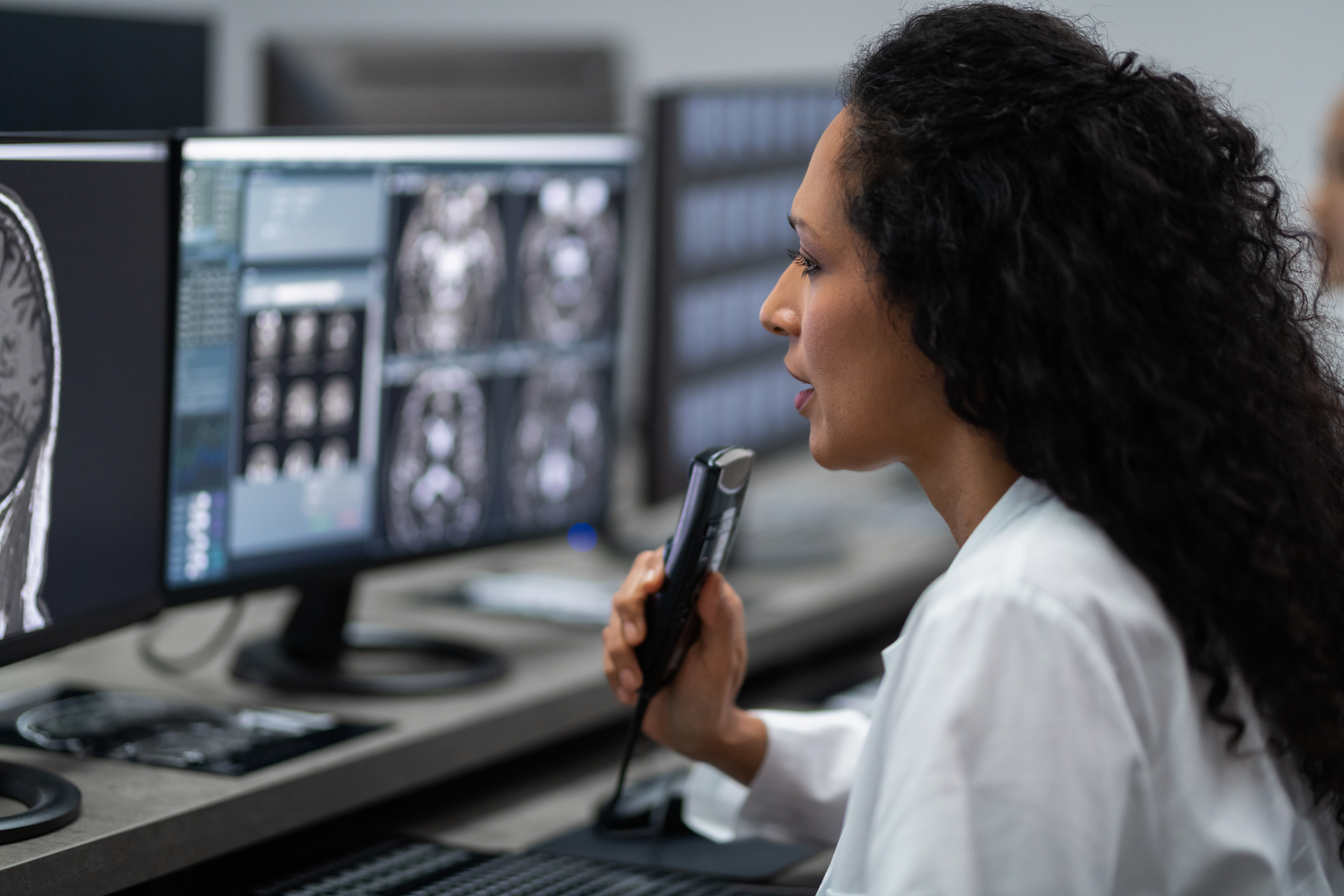 Doctor giving information to woman before MRI scan examination. Magnetic resonance imaging technology in specialized medical clinic.